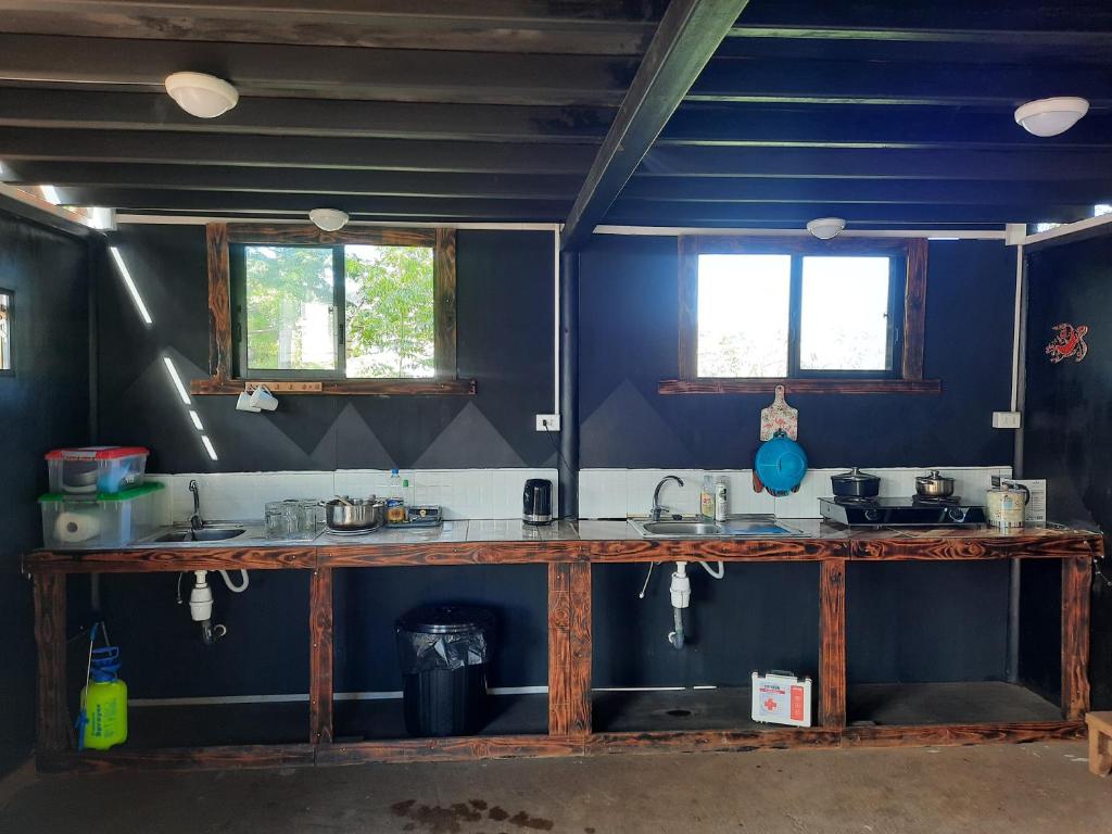 安加罗阿Moehiva Camping Rapa Nui的厨房拥有蓝色的墙壁,配有2扇窗户的台面
