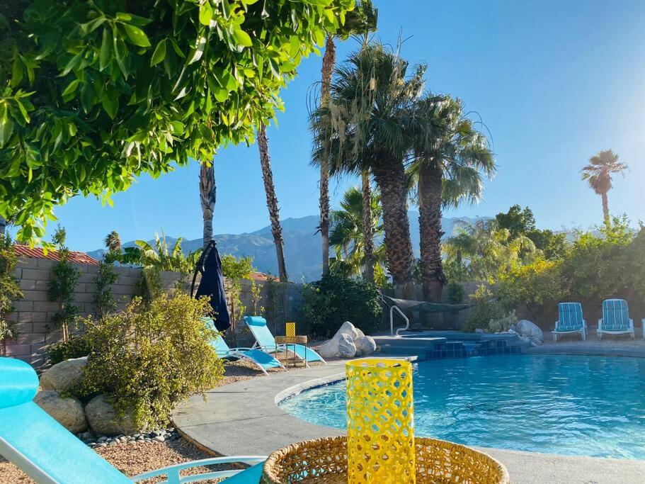 棕榈泉Dreamy Palm Springs Villa w Pool, Spa, Great Views的度假村内一座带棕榈树和椅子的游泳池