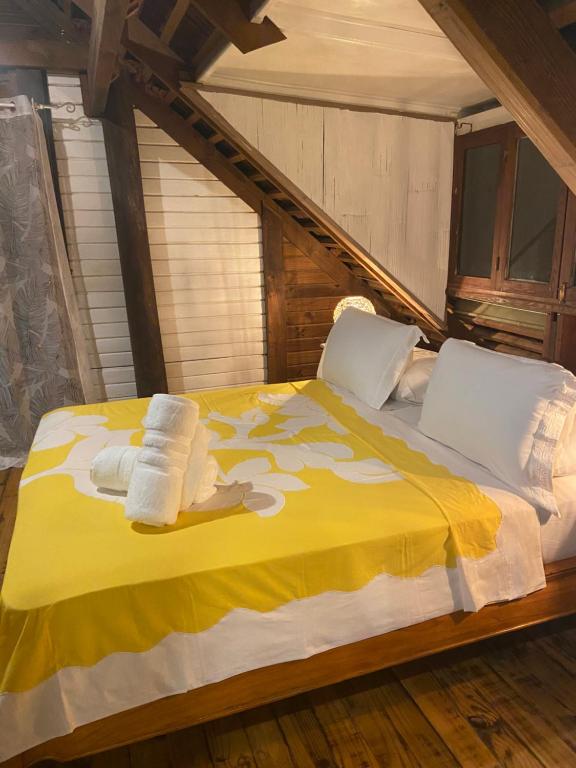 TemaeGreat House BY Manaeva Lodge的一间卧室配有黄色的床和毛巾