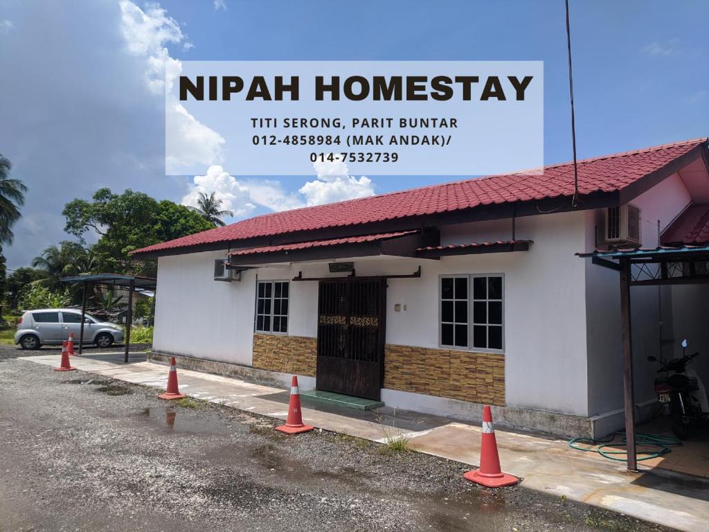 巴力文打Nipah Homestay Parit Buntar的前面有橙色锥形的建筑