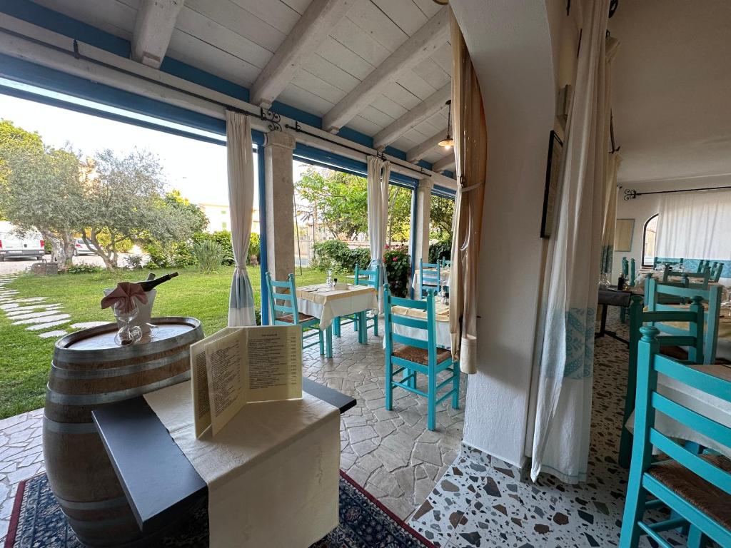 奥罗塞伊Hotel S'Ortale的庭院设有蓝色的椅子和一张带花瓶的桌子。