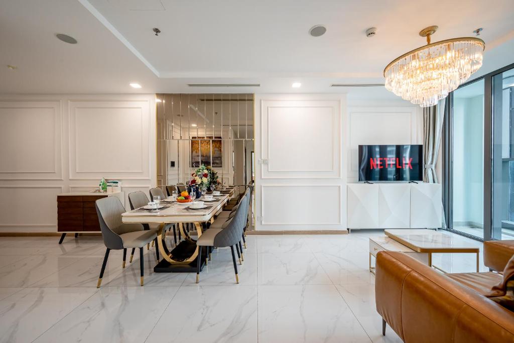 胡志明市Landmark 81 Vinhomes Central Park Luxury Apartment的一间带长桌和椅子的用餐室