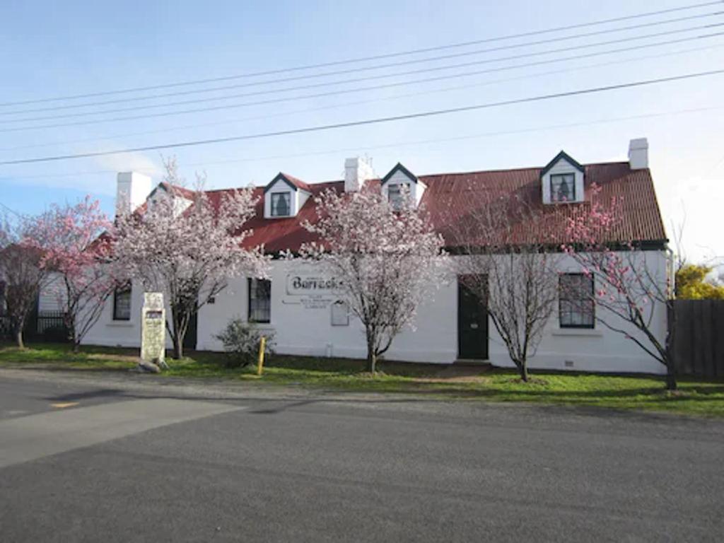 Sorell索雷尔住宿加早餐旅馆的白色的建筑,有红色的屋顶和树木
