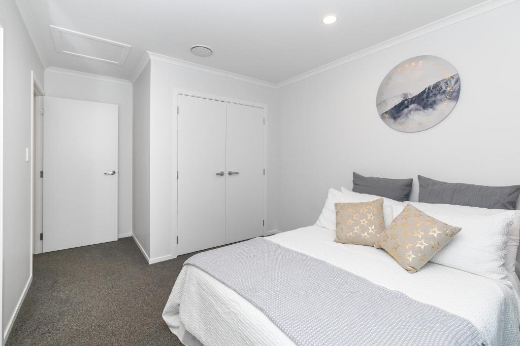 汉密尔顿Comfy Stay Close to City Center的白色卧室配有一张带枕头的大白色床