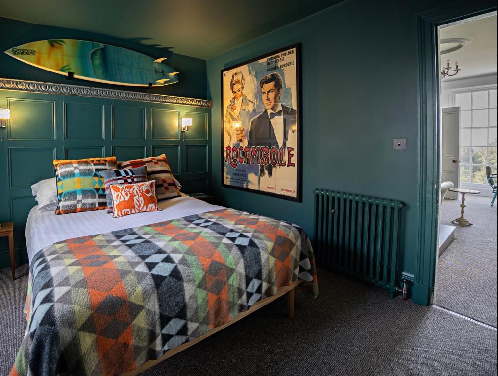 伊尔弗勒科姆Paramount Apartments Ilfracombe, arty seaside holiday apartments的卧室配有一张壁挂式海报的床