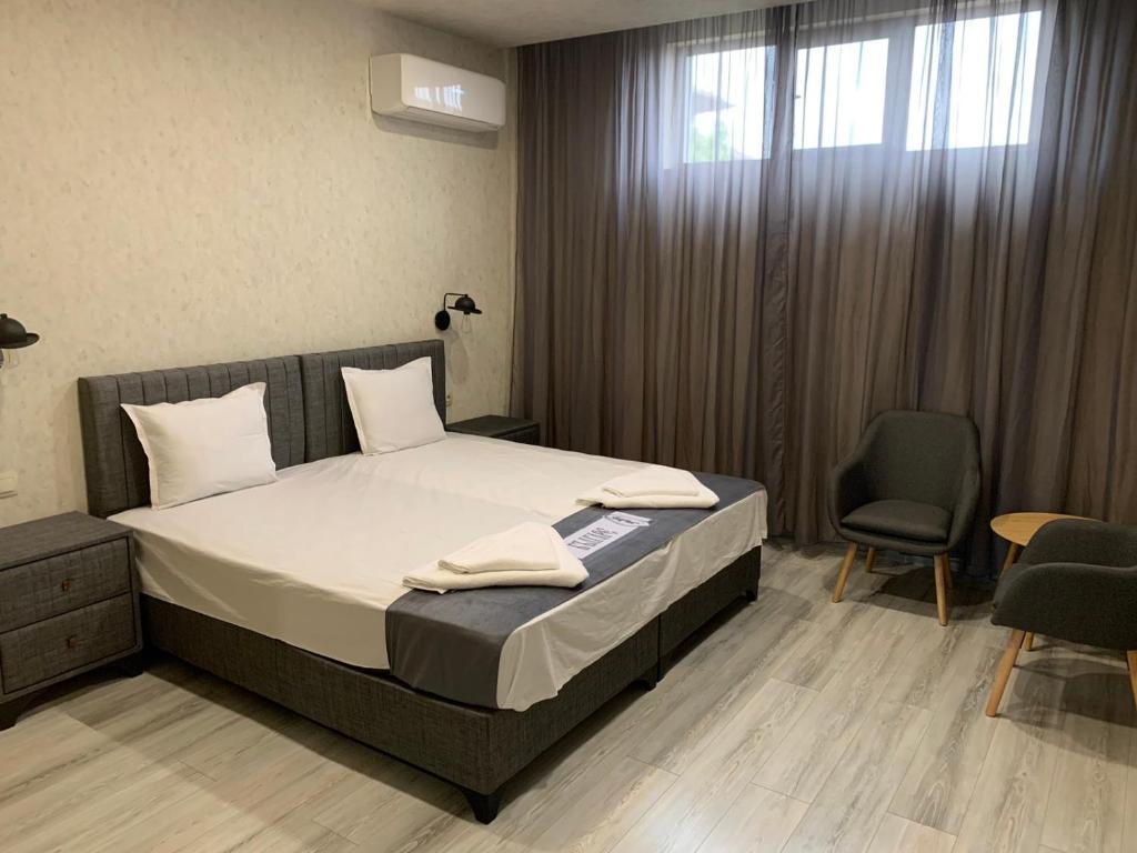 VratsaСтандартна стая Пламен的卧室配有床、椅子和窗户。