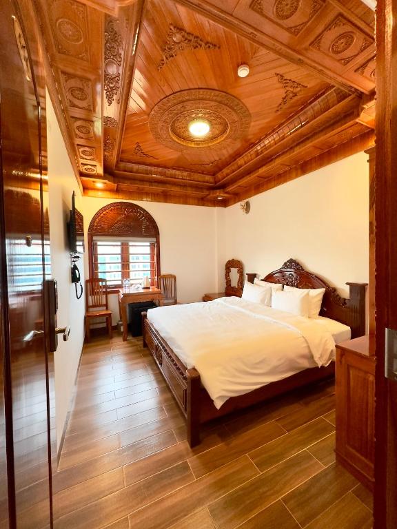 波来古市Hotel Hoàng My的一间卧室设有一张床和木制天花板