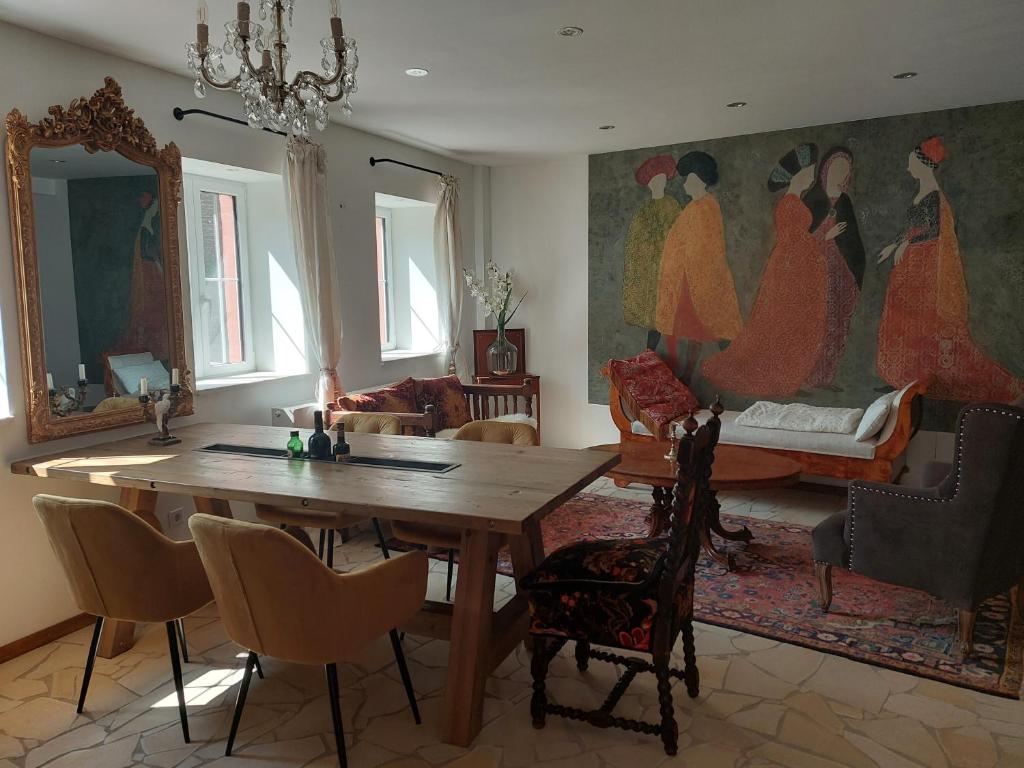 马林诺维德Romantisches Ferienhaus in Moselnähe的一间设有一张桌子和一幅妇女画的用餐室