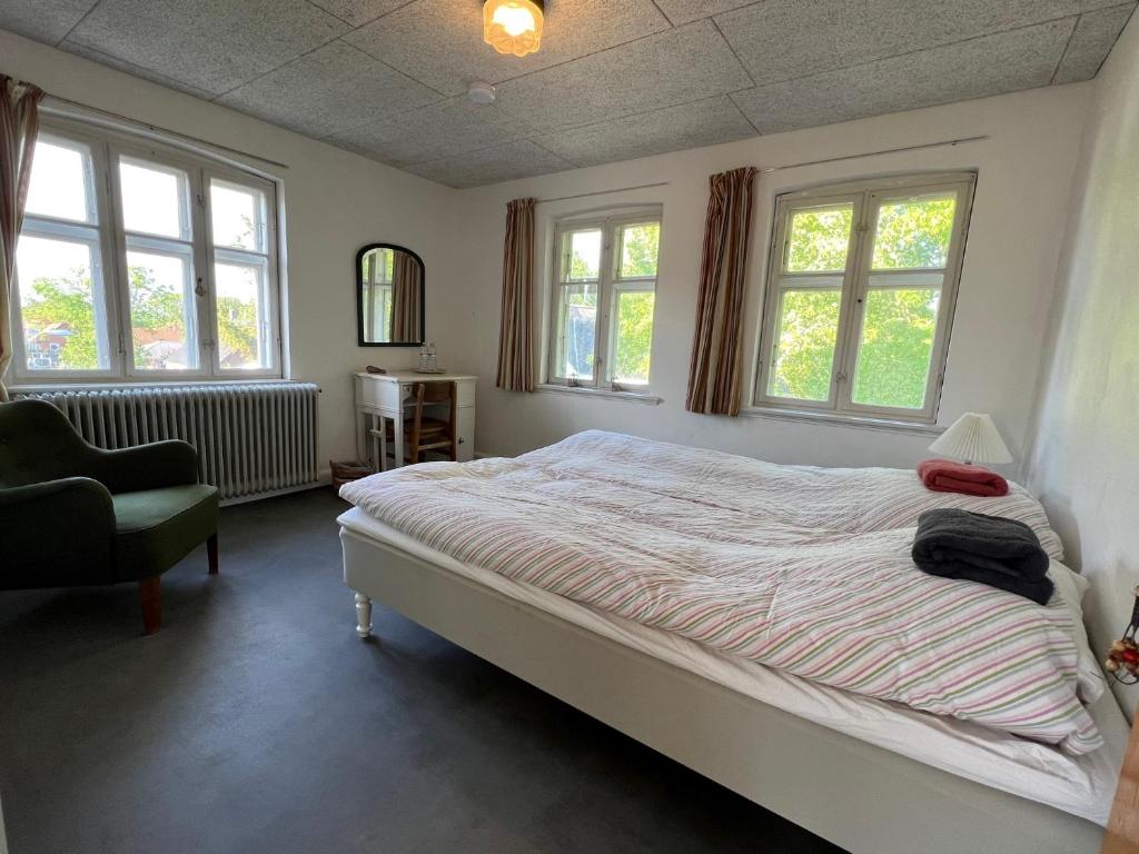 SejerbySejerø Vandrehjem的一间卧室配有一张床、一把椅子和窗户。