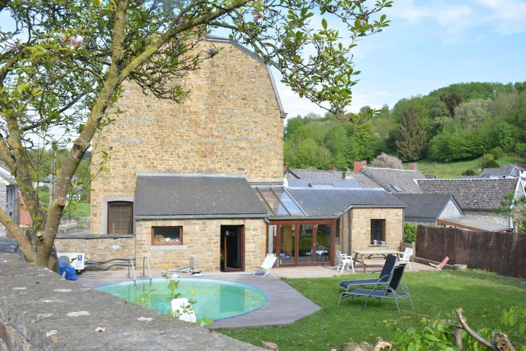 MarchinGranny Cottage.的一座石头房子,在庭院里设有一个游泳池