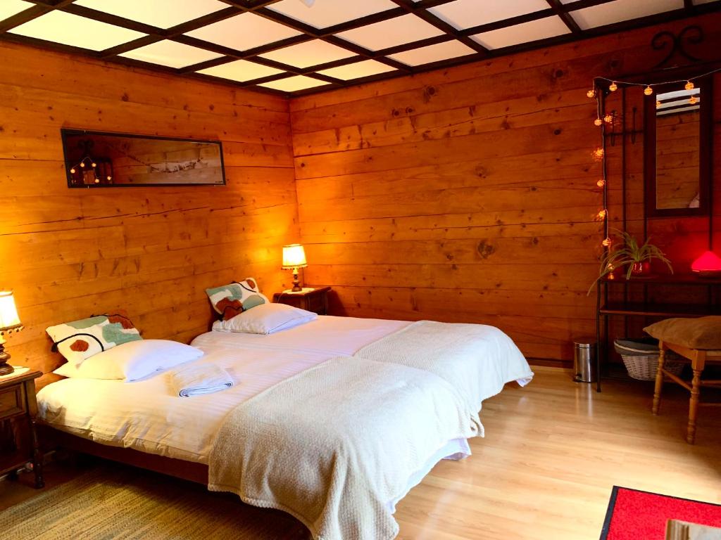 Vernamiège韦纳米耶热住宿加早餐旅馆的一间卧室配有一张带木墙的大床