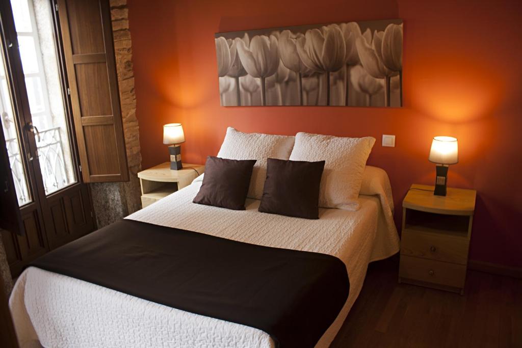 圣地亚哥－德孔波斯特拉PR巴达拉达酒店的一间卧室配有一张带橙色墙壁的大床