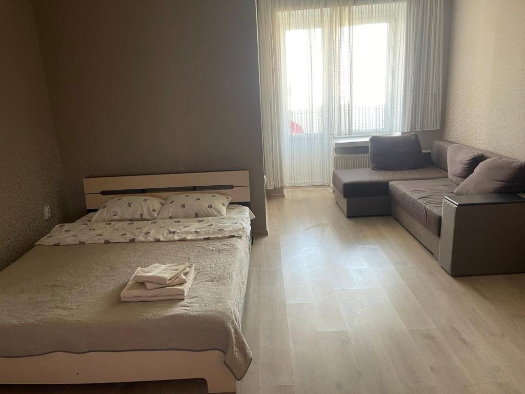 卢茨克Однокімнатна квартира Olympya біля парку Героїв Майдану的一间带两张床和一张沙发的小卧室