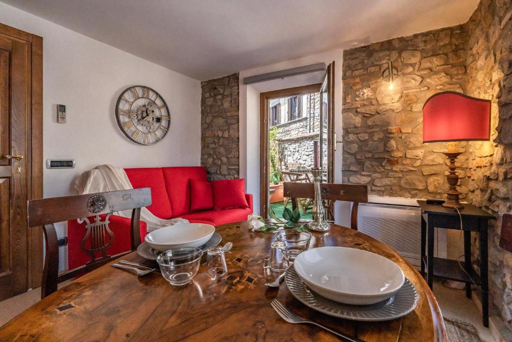 NievoleRomantic apartment with terrace的一间带桌子和红色沙发的用餐室