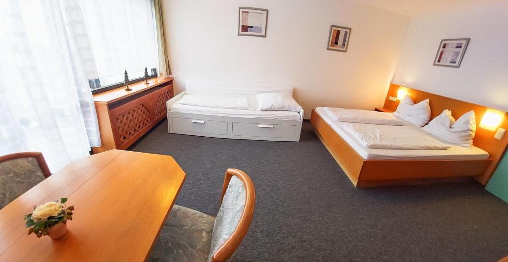 菲利普斯罗伊特Apartmán s výhledem Almberg 336的酒店客房设有两张床和一张桌子。