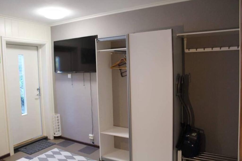 VereideSmall Cozy Apartment in Gloppen的客房设有一个衣柜、一台冰箱和一扇门