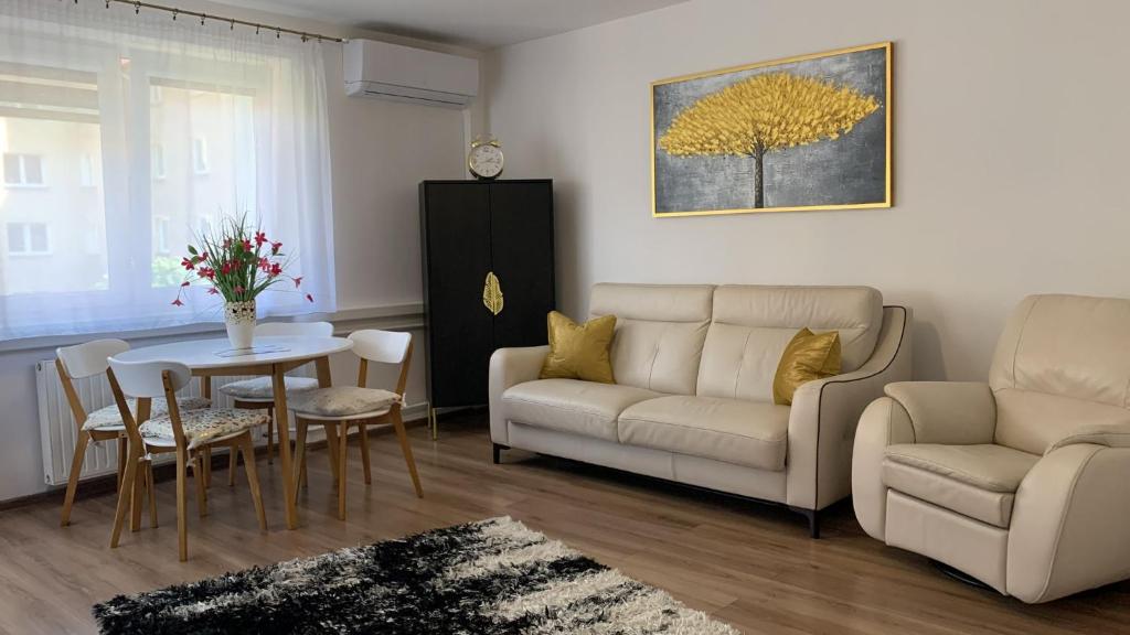 托伦Golden Apartament Legionów的客厅配有沙发和桌子