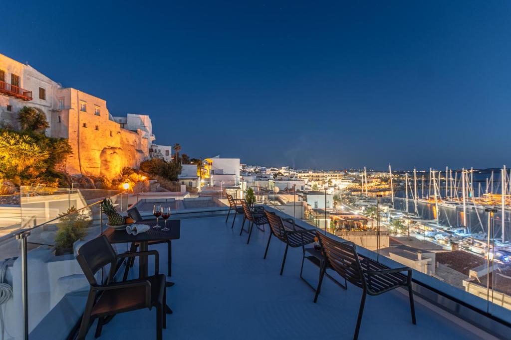 纳克索乔拉Mariet Naxos Spa & Suites的阳台配有桌椅,享有海港的景致。