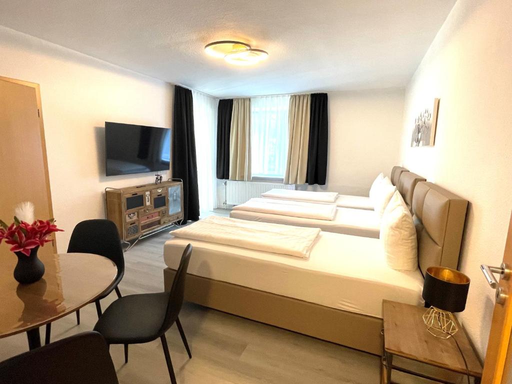汉诺威Park-Residenz Isernhagen的酒店客房设有一张大床和一张桌子。