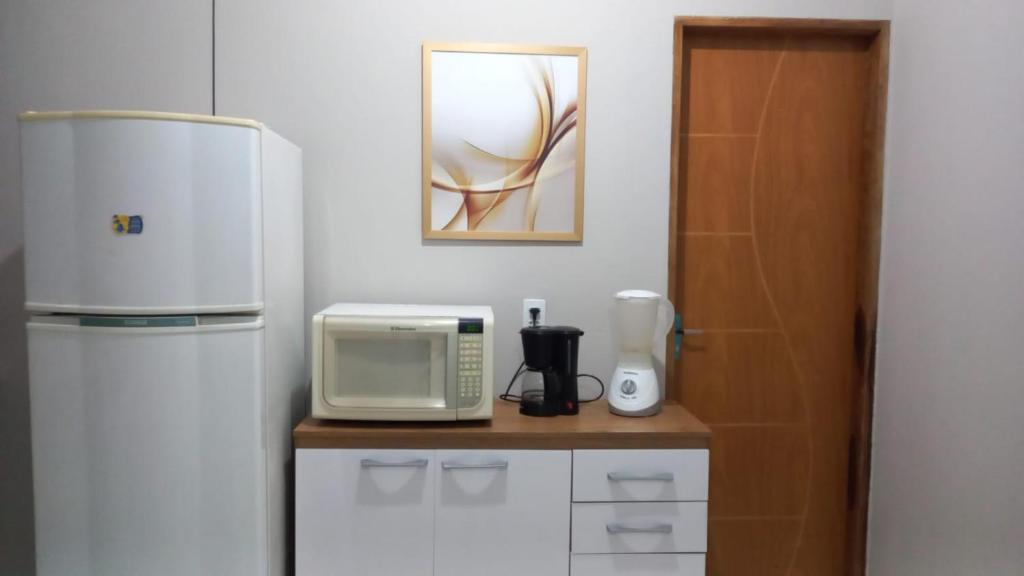 卡鲁阿鲁Casa Confortável的厨房配有冰箱和微波炉。