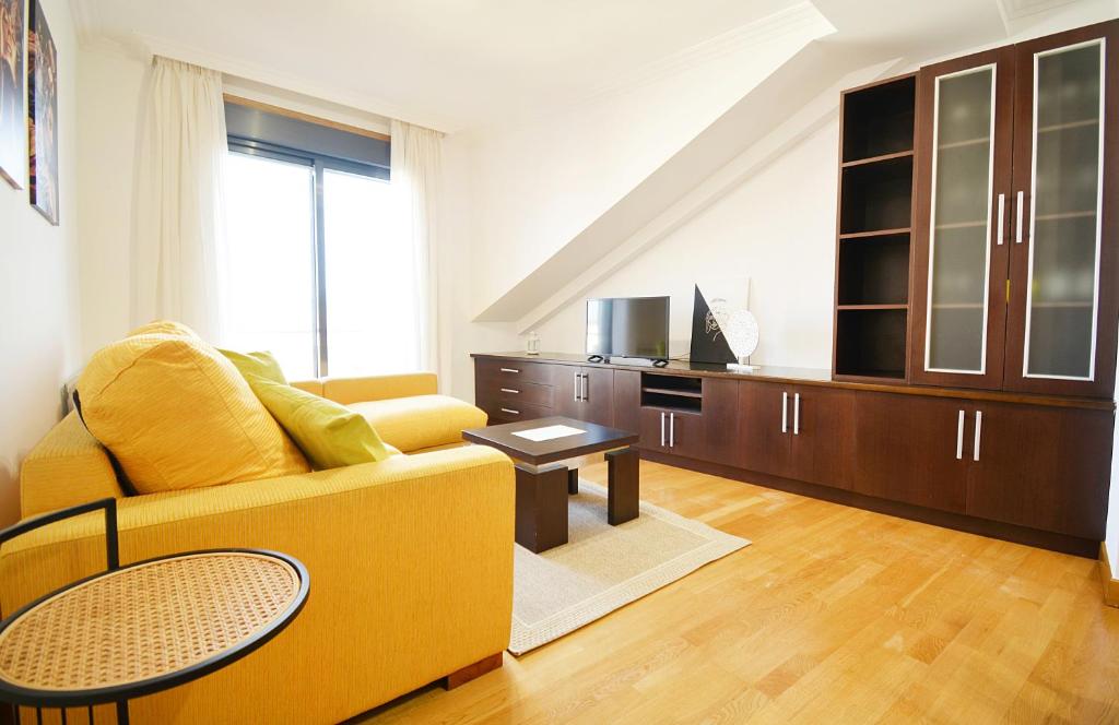坎巴多斯Céntrico apartamento con parking en Cambados的客厅配有黄色的沙发和桌子