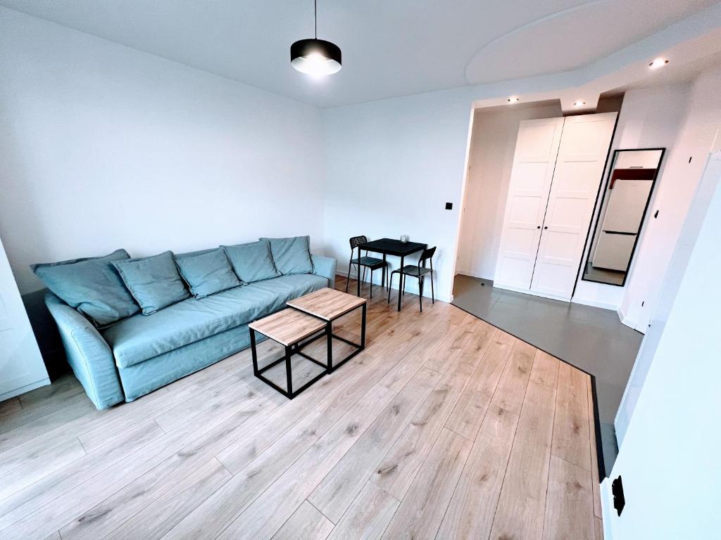 托伦Apartament Zbożowa的客厅配有蓝色的沙发和桌子