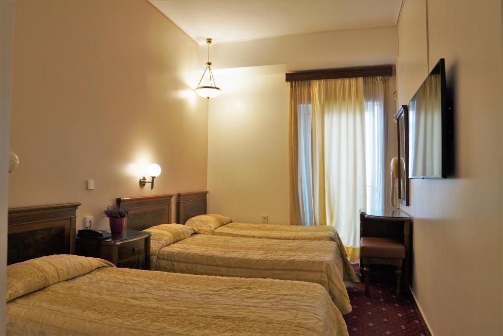 雅典巴拉斯卡酒店的酒店客房设有三张床和窗户。