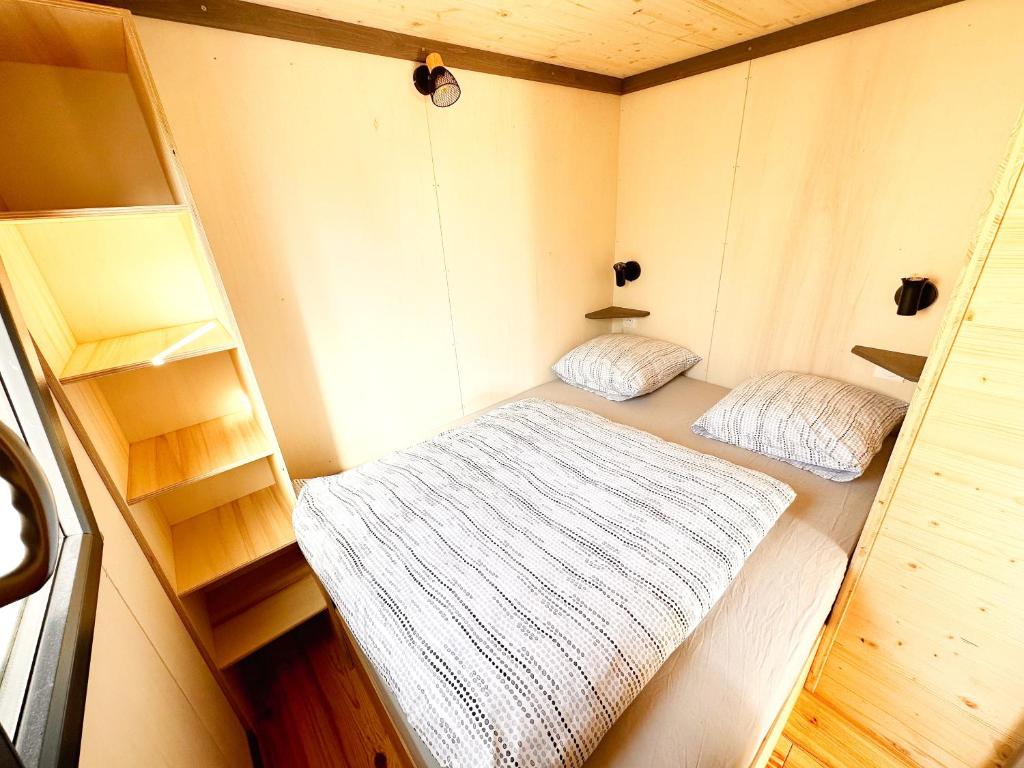 绍莱tiny house的一间小房间,配有两张床和架子