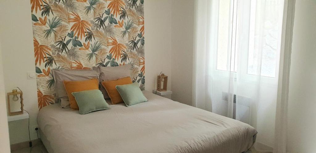 PierrevertUne maison en Provence的一间卧室配有带枕头的床铺和壁纸