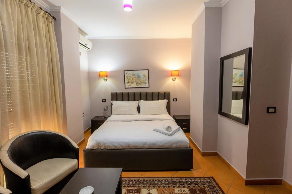 地拉那王子酒店的一间卧室配有一张床、一张桌子和一把椅子