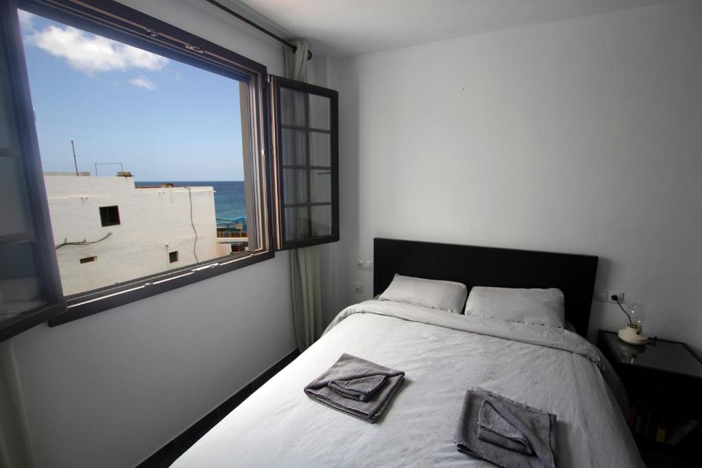 阿列塔La Casa del Atlántico的一间卧室设有一张大床和大窗户