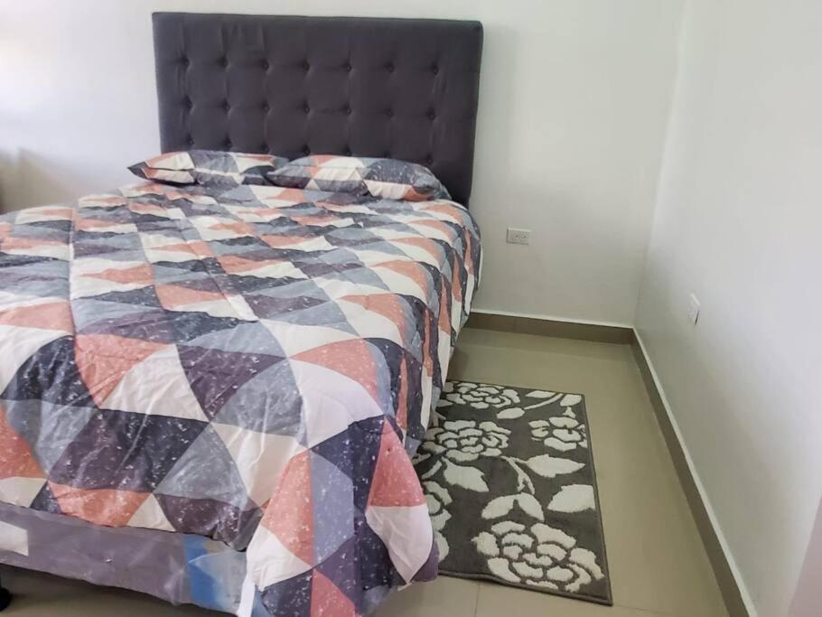 科尔特斯港Apartamentos y Hostal Rudon # 5的一间卧室配有床,床上配有被子和地毯