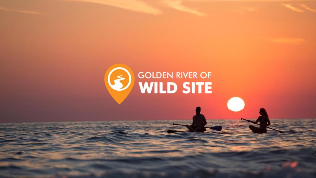 BhurkīāGolden River of wild side的两人坐在海洋里,欣赏日落
