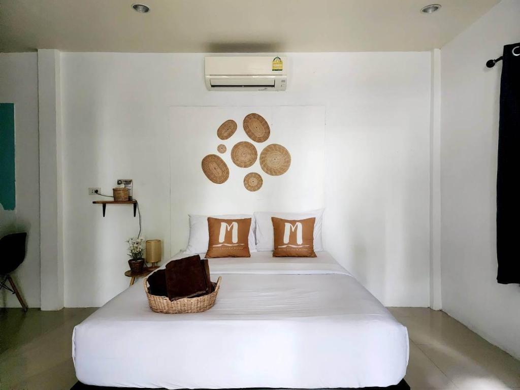 沙美岛明妮海景度假村 的卧室配有带棕色枕头的大型白色床