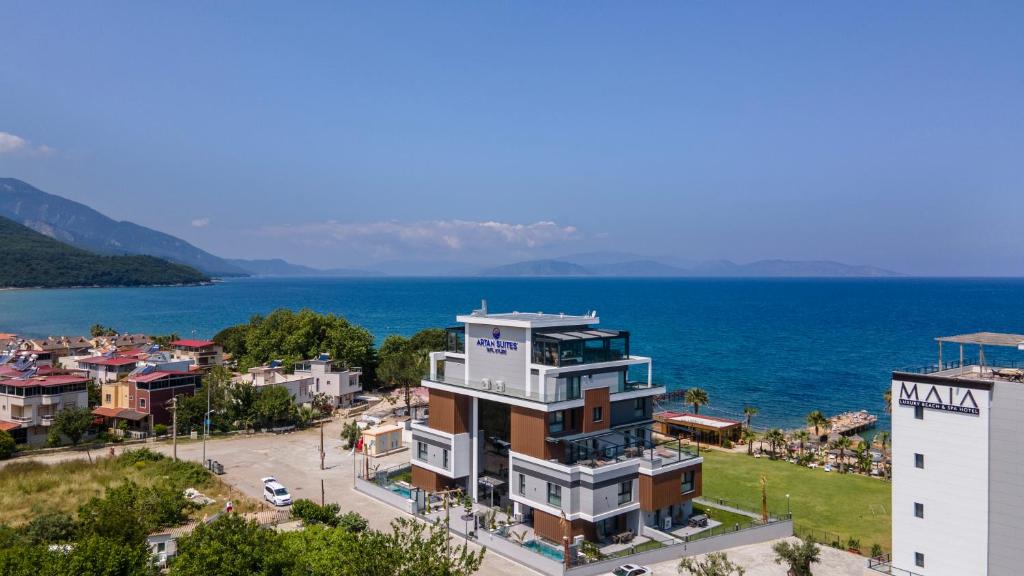 古泽尔坎里Artan Suites Tatil Evleri的水面上一座城市旁边的建筑