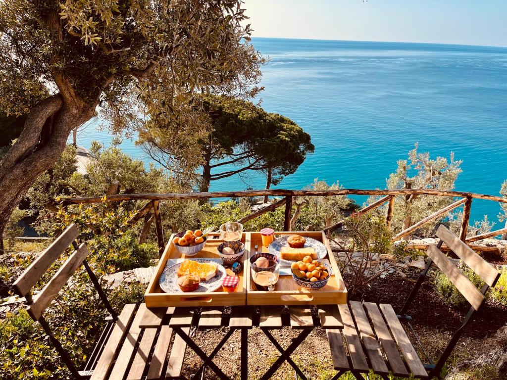 菲纳莱利古雷Eufonia del Mare的一张桌子,上面有食物,后面有海洋