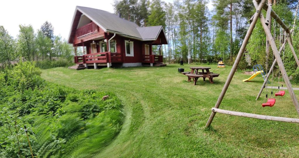 卡拉约基Kivitasku的红色小屋设有野餐桌和游乐场