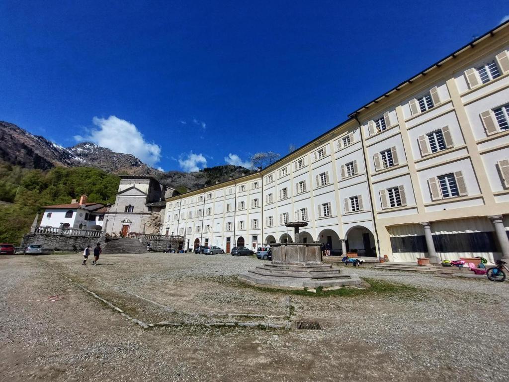 Campiglia CervoLocanda del Santuario的一座白色的大建筑,前面有一个喷泉