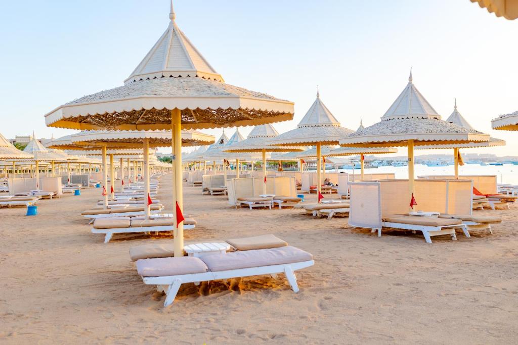 赫尔格达The Grand Hotel, Hurghada的沙滩上带椅子和遮阳伞的海滩