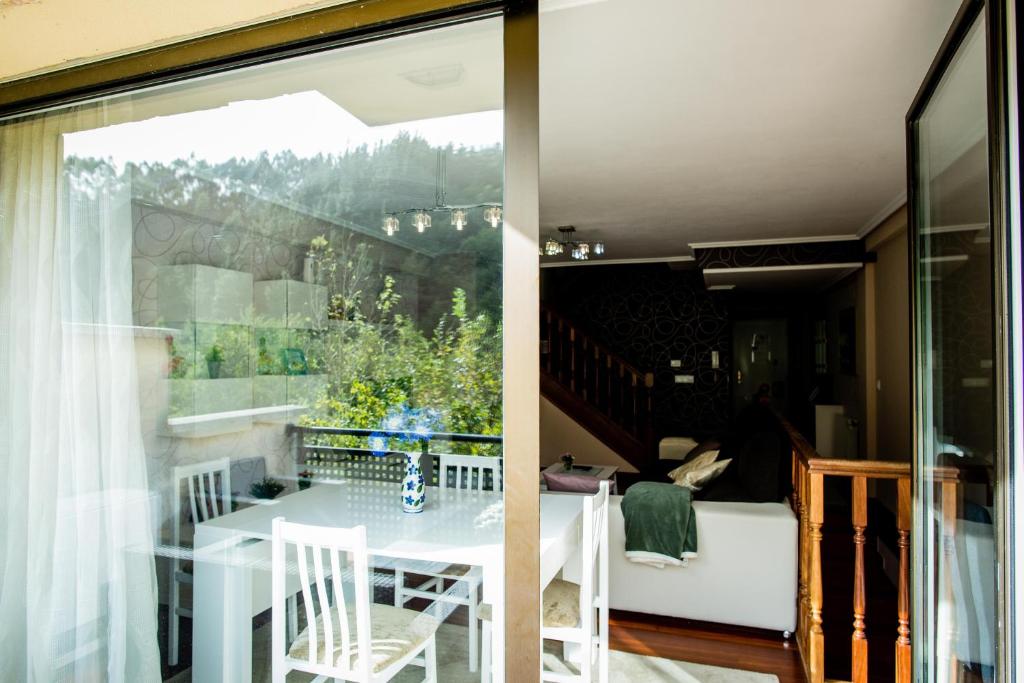 MendiondoCasa con terraza para 4 personas en Plentzia的一间带桌子和窗户的用餐室