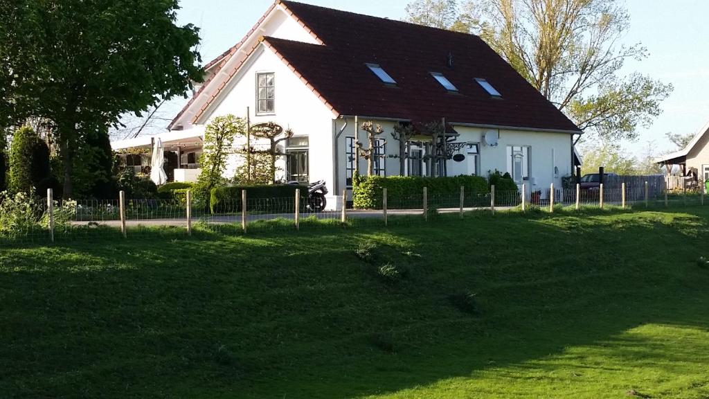 海勒富特斯勒斯Logement Hellevoetsluis的一间白色的房子,有棕色的屋顶和院子