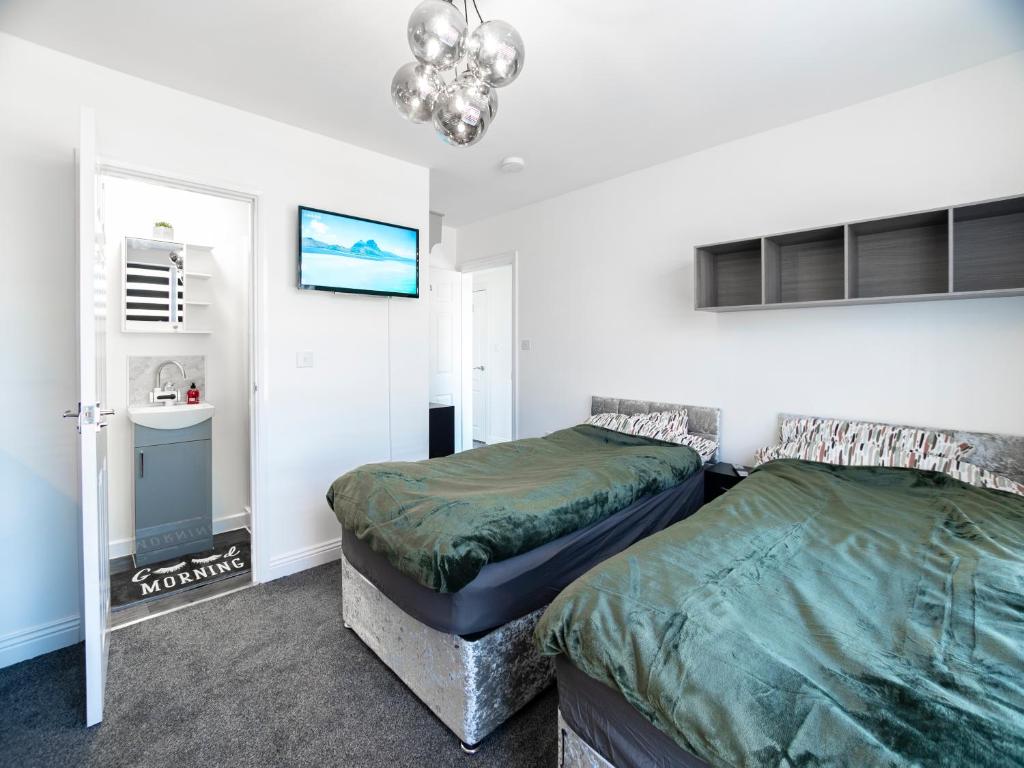 曼斯菲尔德Mansfield Town Centre Flats的一间卧室配有两张床和吊灯。