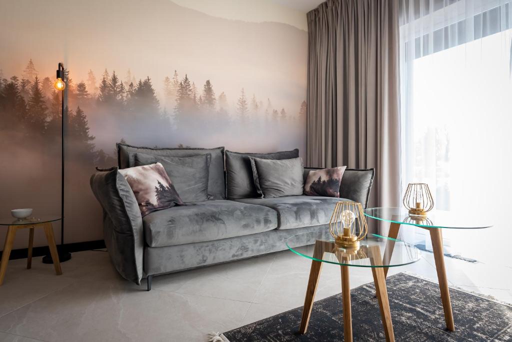 扎热切Apartament Premium 28 Laguna Beskidów nad Jeziorem Żywieckim - Dream Apart的客厅配有一张沙发,墙上挂着森林壁画