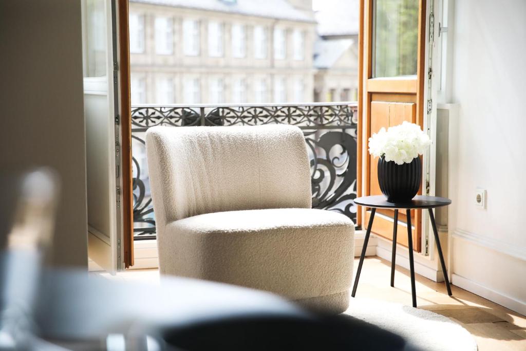 威斯巴登Palais Passy~Design Suite mit Ausblick im Zentrum的坐在花瓶阳台的椅子
