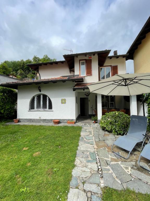 BrusimpianoVilla Mia Lugano Lake的院子里带遮阳伞和椅子的房子