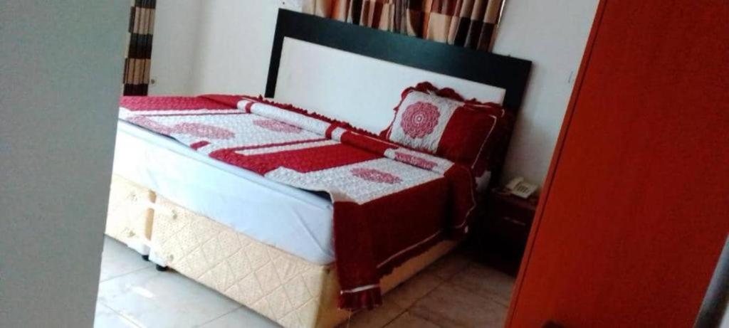 基加利SILVER HOTEL APARTMENT Near Kigali Convention Center 10 minutes的客房内的一张红色和白色的床