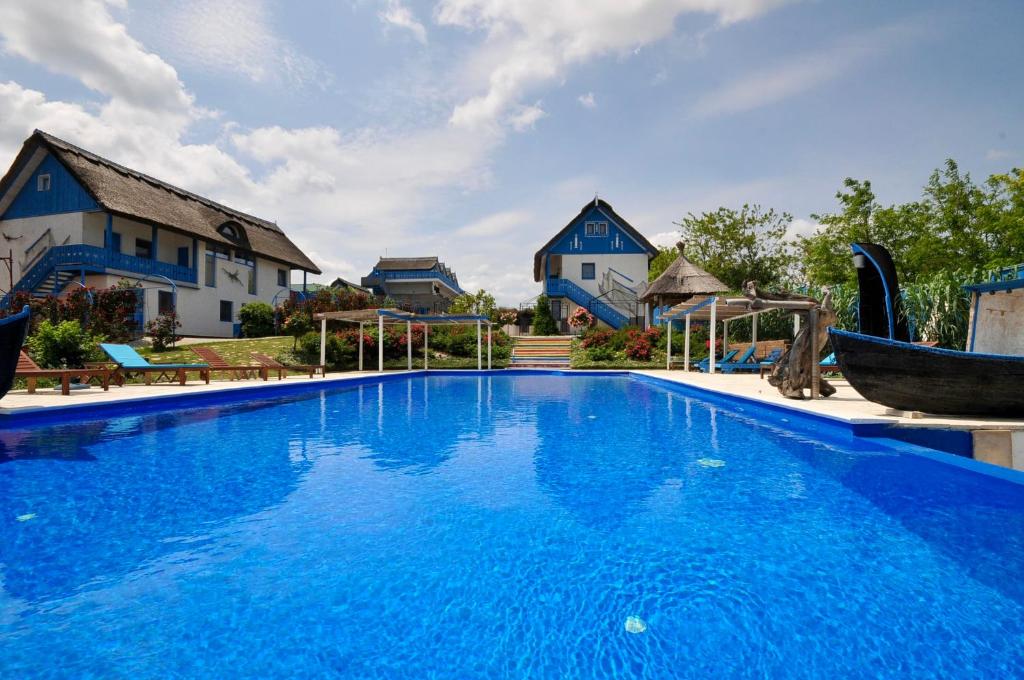 杜纳厄图德乔斯Nena Art Resort的一座大蓝色游泳池,位于房子前