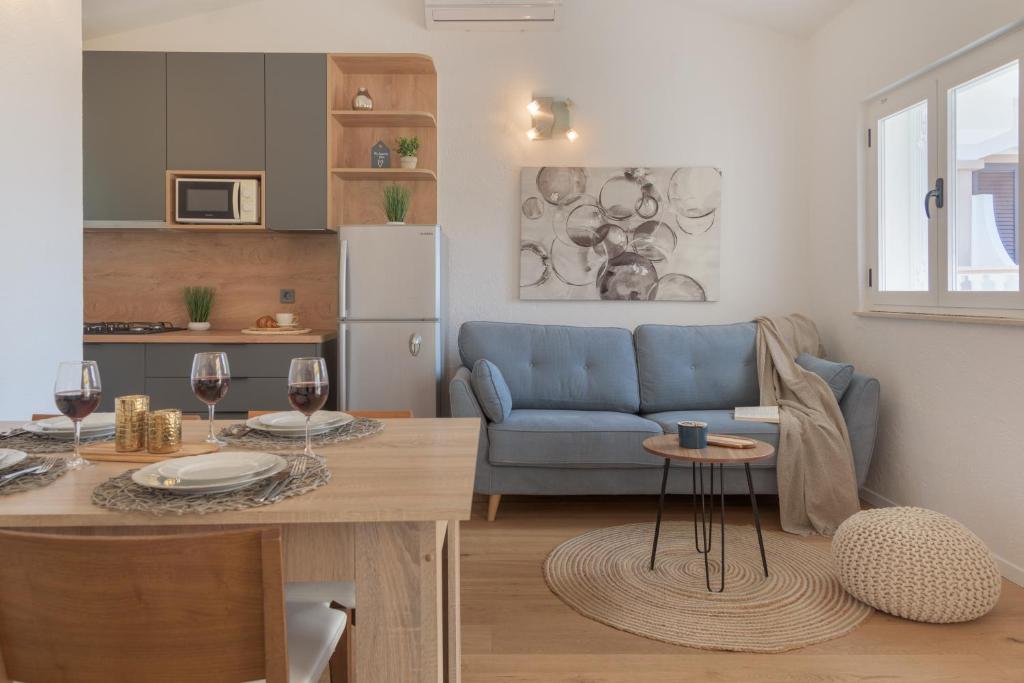 帕科坦Cozy Apartment - 100m from the beach Punta的厨房以及带蓝色沙发和桌子的客厅。
