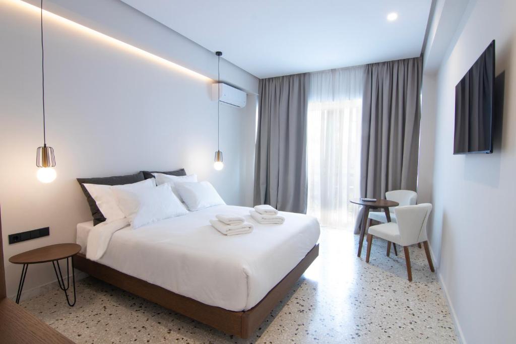 雅典Mythodea Athens Suites的酒店客房带一张床、一张桌子和椅子