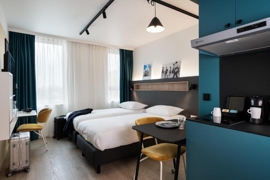 根特Adagio Access Gent Centrum Dampoort的酒店客房配有一张床铺和一张桌子。